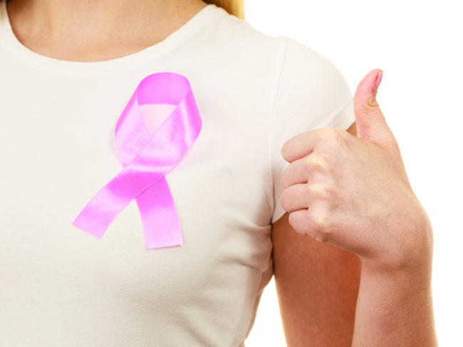 Closeup pink cancer ribbon on woman chest