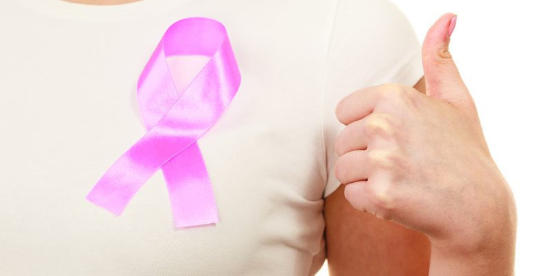 Closeup pink cancer ribbon on woman chest